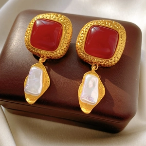 Detail of vintage square red resin earrings with gold metal frame and baroque pearl drop