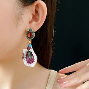 Close-up of vintage flower earrings with red teardrop stones on dark background