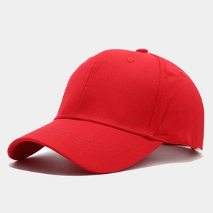 Close-up of a bright red cotton baseball cap with ventilation eyelets and curved brim