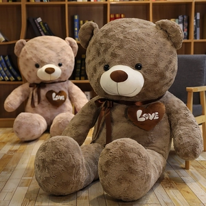 Brown and tan plush teddy bears with embroidered heart patches on a cozy wooden shelf