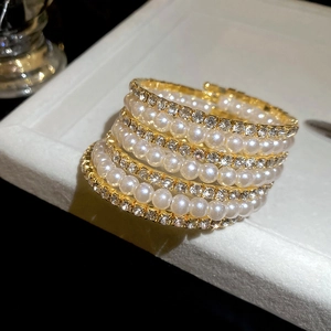 Detail of multilayer pearl bracelet with shimmering rhinestones on a golden base