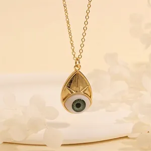 Detail shot of a teardrop Evil Eye pendant in 18K gold plating with green eye inlay