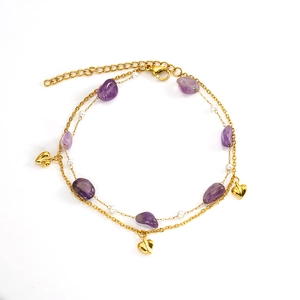 Detailed macro view of gold chain with purple natural stones and small heart charms
