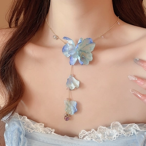 Detail of fabric flower necklace featuring gradient blue petals and purple water drop pendant