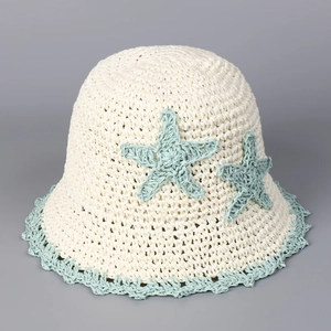 Detailed close-up of handmade cream straw bucket hat with mint green starfish crochet pattern