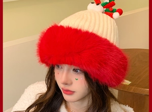 Close-up of knit Christmas hat with fluffy red faux fur brim and cute reindeer antlers