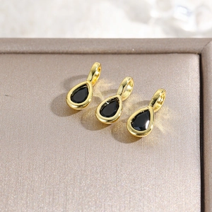 Macro shot of three teardrop pendants with black stones in 18k gold-plated frames