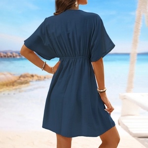 Back view of a navy blue ice silk beach cover-up with drawstring waist on a sunny shore