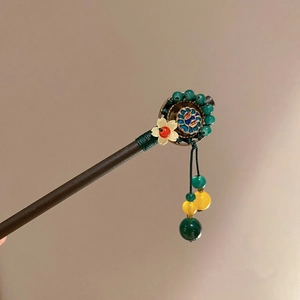 Détail d'un pic à cheveux en bois avec disque cloisonné, fleur et pompon en soie verte