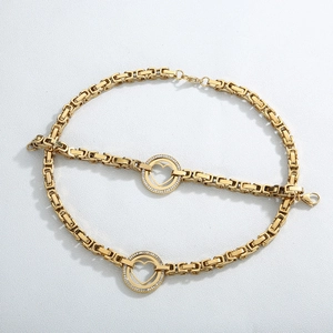 Macro detail of gold Byzantine chain necklace and bracelet set with cubic zirconia heart
