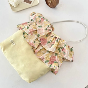 Detail van de bloemen ruiderrand en merklabel op een vintage katoenen schoudertas