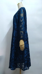 Detailed side view of dark blue long-sleeve lace dress with floral hollow patterns