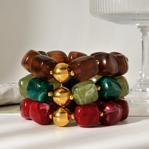 Three-piece beaded bracelet set featuring vintage resin beads and gold metallic accents