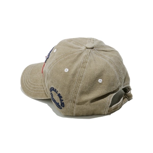 Side view of khaki washed cotton baseball cap with blue embroidery and contrast stitching