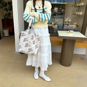 Detail view of white corduroy tote bag featuring Keep Smiling text and yellow smiley face