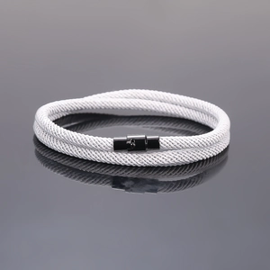 Detailed close-up of white braided couple bracelet with black magnetic clasp mechanism