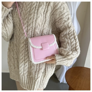 Détail du petit sac carré rose en similicuir avec bordure en fausse fourrure blanche