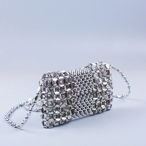 Detail of silver woven bead chain handbag with metallic texture and matching strap