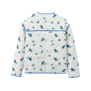 Close-up of blue floral print on white quilted cotton jacket with blue contrast trim