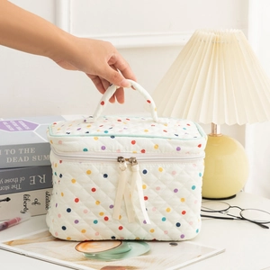 Detailed macro view of quilted makeup bag with colorful polka dots on a cozy desk
