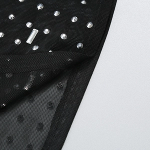 Detail of sheer black mesh fabric with sparkling rhinestones and crystal decoration
