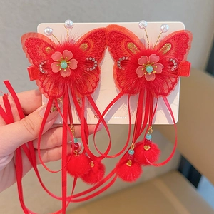 Detail of red Chinese style butterfly hair clips with embroidery and long ribbon tassels