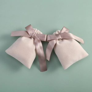 Detail of velvet drawstring jewelry pouch with elegant satin bow on a green background