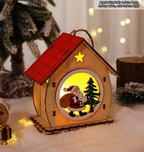 Macro detail of wooden LED Christmas house with red roof and warm glowing light