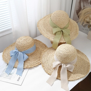 Three wide brim raffia straw sun hats with colorful fabric bows and frayed edges