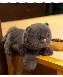 Primer plano de un gato de peluche British Shorthair gris oscuro sobre madera