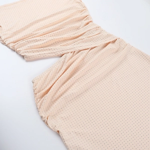 Détail de robe rose avec micro-strass, tissu froncé élégant et découpe latérale design