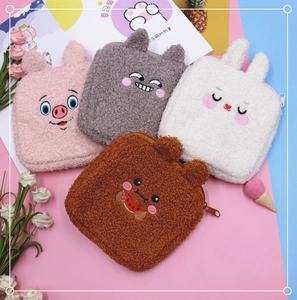 Flat lay of cute plush sanitary napkin bags featuring embroidered animal faces and soft texture