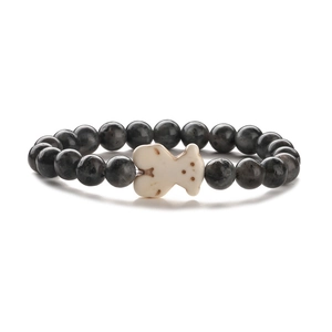 Dettaglio del bracciale con perline occhio di tigre e pietra bianca a forma di orsetto