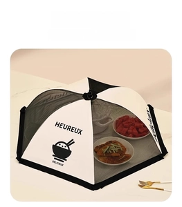 Close-up of foldable food cover mesh with black lace edge on a marble table