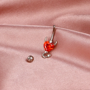 Silver devil heart belly button ring with red zircon on pink silk background