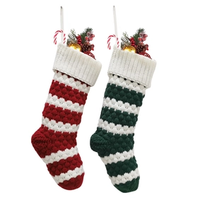 Knitted Christmas stockings with red and green stripes featuring festive holiday decor
