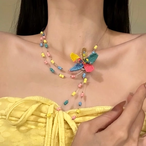 Detailed view of a colorful dopamine style beaded flower necklace on a model