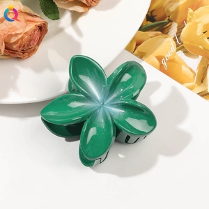 Detail of green floral claw clip with gradient center and sparkling glitter finish