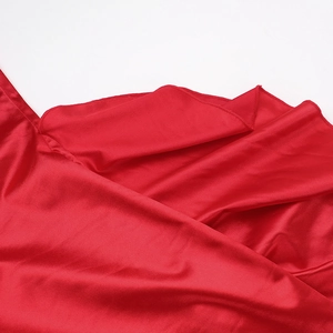 Détail macro du satin de soie rouge montrant la texture lisse et le drapé du tissu