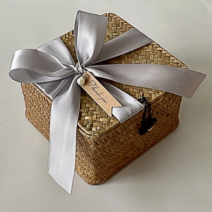 Detail of hand-woven gift basket with grey satin ribbon, pearl and Thank You tag