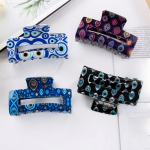 Set of four Evil Eye pattern acetate hair claws in blue, purple, and black colors