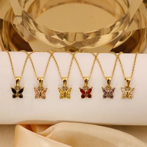 Detailed display of six gold butterfly pendants with colorful zircon stones on a stand