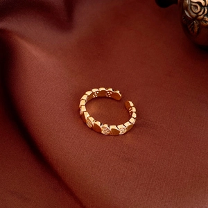 Detail of gold-plated oval ring with micro-pave crystals on red silk background