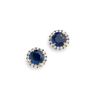 Macro shot of gold halo earrings with round dark blue sapphire and diamond accents