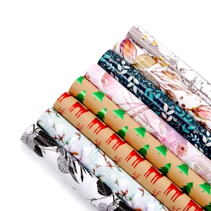 Assorted gold foil gift wrapping paper rolls with floral and Christmas pine tree patterns