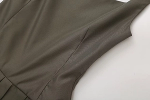 Detail of dark olive pleated dress featuring high-quality twill fabric and refined seams