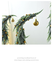Macro detail of snow-flocked cedar branch with gold ornament for Christmas decor