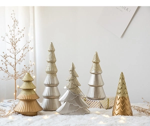 Set of mini Morandi green and metallic Christmas tree ornaments on a snowy backdrop