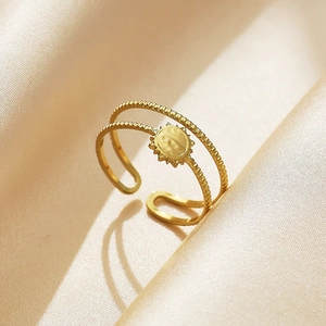 Close-up of gold double-layer star and heart open ring on silk fabric background