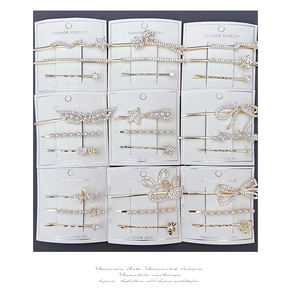 Detail of 3-piece gold hair clip sets with rhinestones and faux pearls on display cards